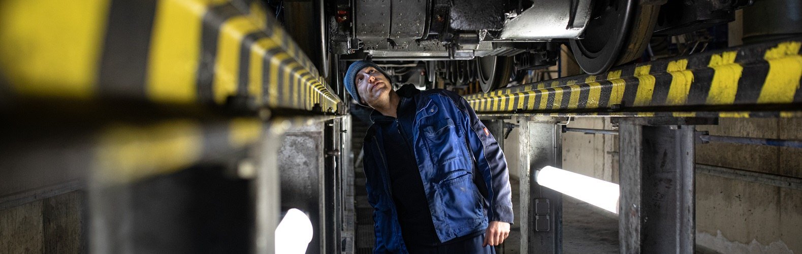 Exklusiver Blick in die Bahnwerkstatt der Wendelstein-Zahnradbahn: Mitarbeiter kontrolliert Fahrgestell, &copy; fiftyseven.art / Chiemgau Tourismus e.V.