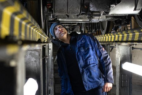 Exklusiver Blick in die Bahnwerkstatt der Wendelstein-Zahnradbahn: Mitarbeiter kontrolliert Fahrgestell, &copy; fiftyseven.art / Chiemgau Tourismus e.V.